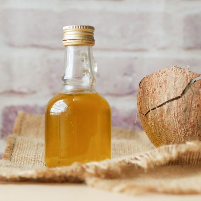 Chai dầu dừa thủy tinh cạnh quả dừa